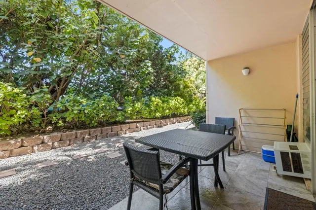 a view of a backyard with table and chairs and potted plants