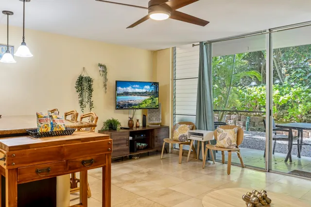 a living room with furniture a flat screen tv and a floor to ceiling window