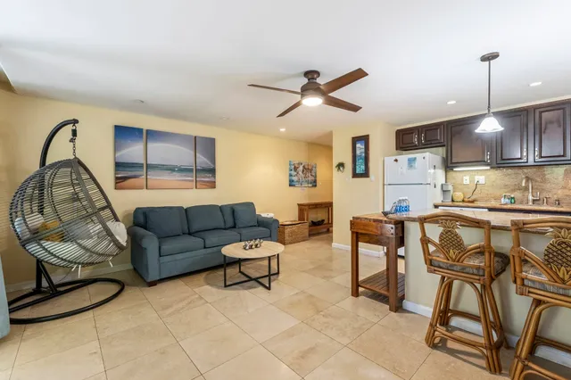 a living room with furniture a rug and kitchen view