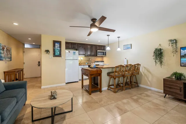 a living room with furniture kitchen view and a chandelier