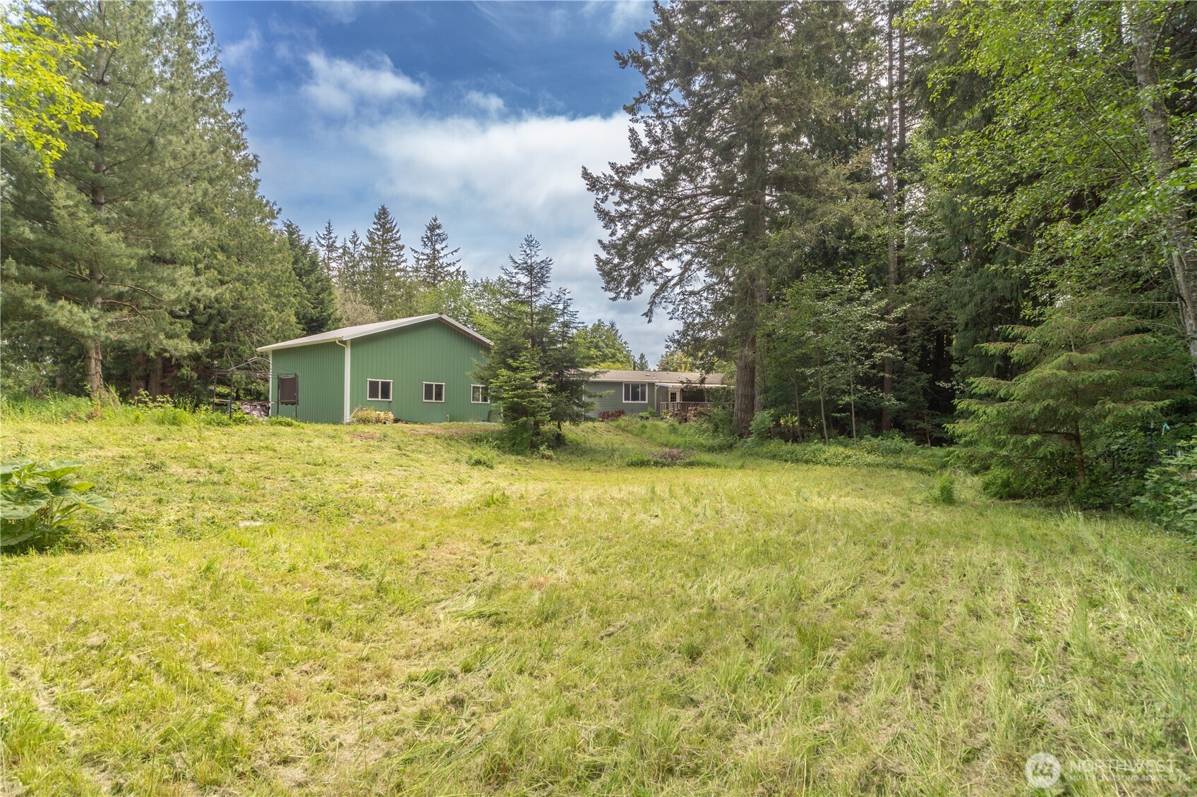 290 Werner Road Port Ludlow, WA 98365 - Photo 38 of 40 a backyard of a house with large trees and wooden fence