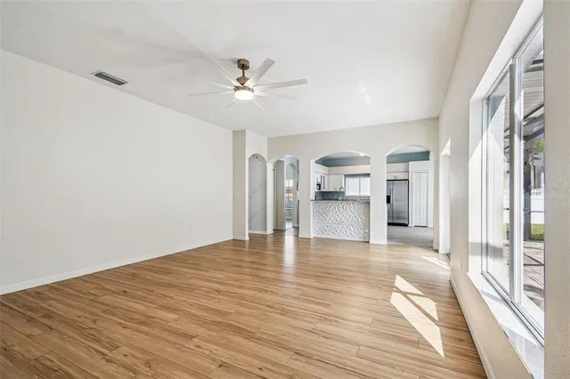 a view of empty room with wooden floor and window