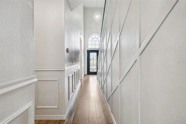 a view of a hallway with wooden floor and entryway
