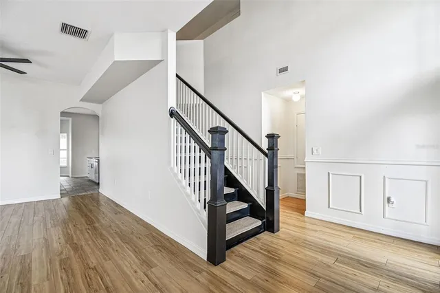 a view of a hallway with wooden floor and staircase