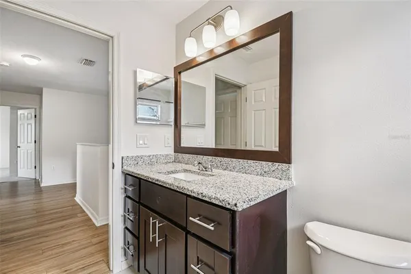 a bathroom with a granite countertop sink and a mirror