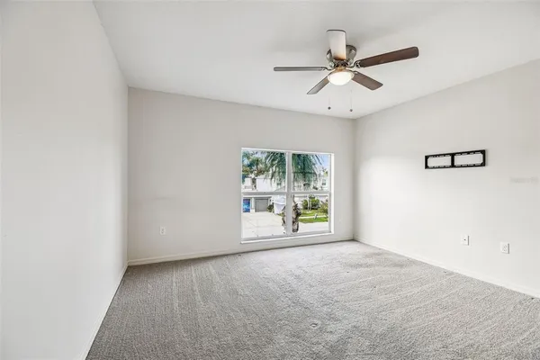 an empty room with fan and windows
