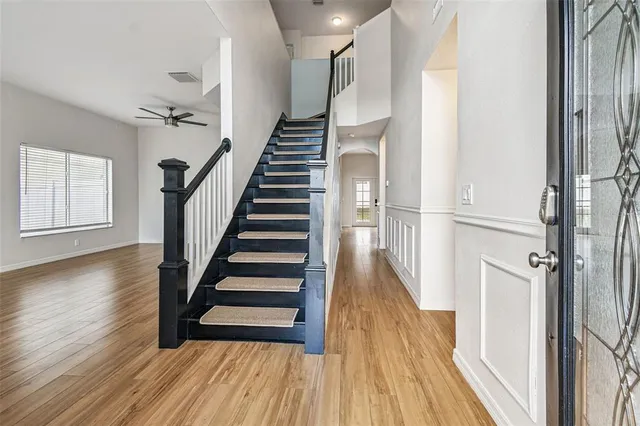a view of a hallway with wooden floor and stairs