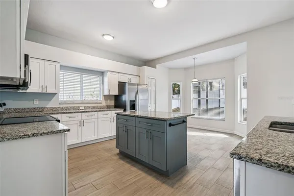 a kitchen with stainless steel appliances granite countertop a stove a sink dishwasher and a refrigerator