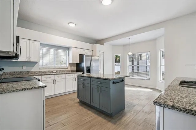 a kitchen with stainless steel appliances granite countertop a stove a sink dishwasher and a refrigerator