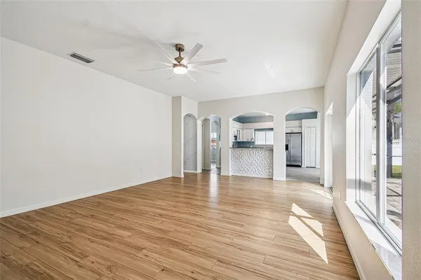 a view of empty room with wooden floor and window
