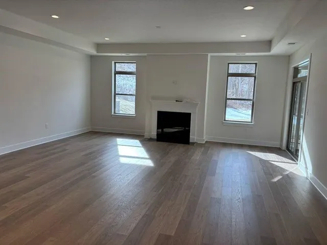 an empty room with windows and a fireplace