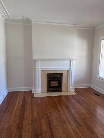 an empty room with wooden floor and fireplace