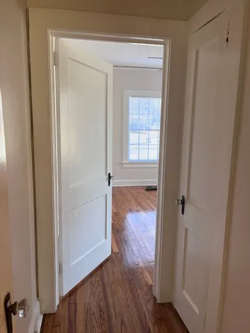 a view of a hallway with wooden floor
