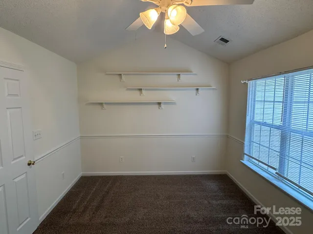 a view of a small space with racks on the wall and a window