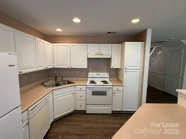 a kitchen with a sink a refrigerator and cabinets
