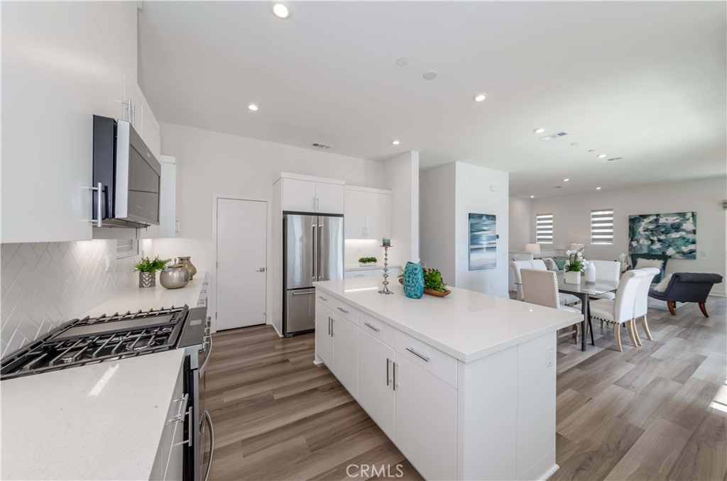 1403 West Bushell Street Anaheim, CA 92805 - Photo 10 of 31 a large white kitchen with lots of counter space and wooden floor