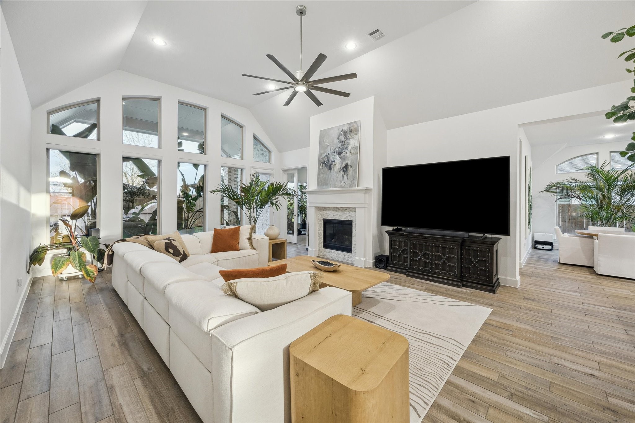 9823 Chapman Trail Manvel, TX 77578 - Photo 17 of 47 Step into this expansive and airy living room, where natural light pours through a breathtaking wall of oversized windows, and the fireplace is ready to help create a warm and cozy ambiance.