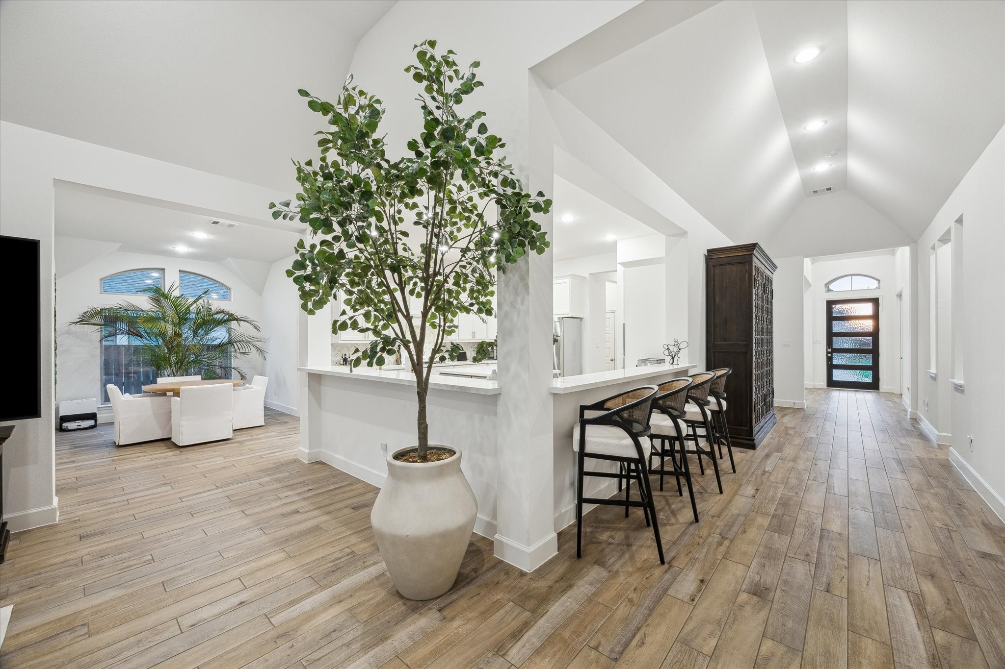 9823 Chapman Trail Manvel, TX 77578 - Photo 9 of 47 This home offers an open-concept layout, wood-look tile flooring, high ceilings, and a modern, airy design. The entry hall leads the way to a stylish kitchen that offers plenty of space for serving and for barstool seating.