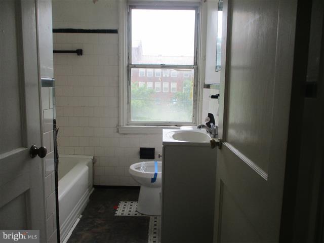 2707 Edison Highway Baltimore, MD 21213 - Photo 15 of 25 a bathroom with a sink toilet and shower