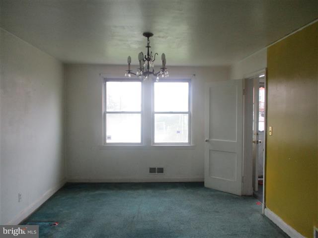 2707 Edison Highway Baltimore, MD 21213 - Photo 4 of 25 an empty room with chandelier fan and windows