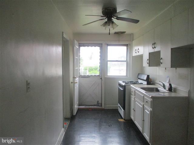2707 Edison Highway Baltimore, MD 21213 - Photo 6 of 25 a kitchen with stainless steel appliances granite countertop a sink stove and refrigerator