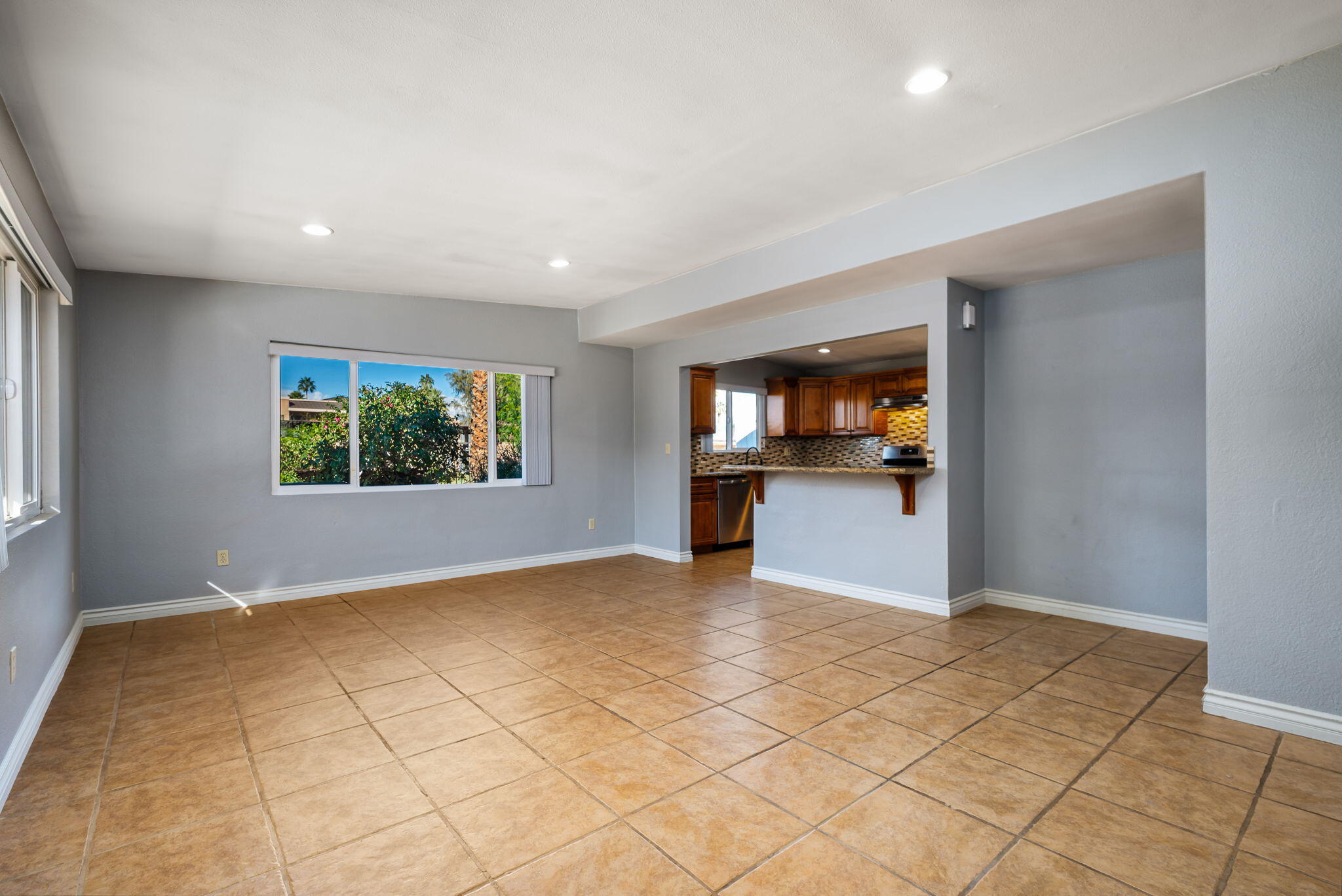 73333 Santa Rosa Way Palm Desert, CA 92260 - Photo 16 of 37 an empty room with kitchen view and natural light