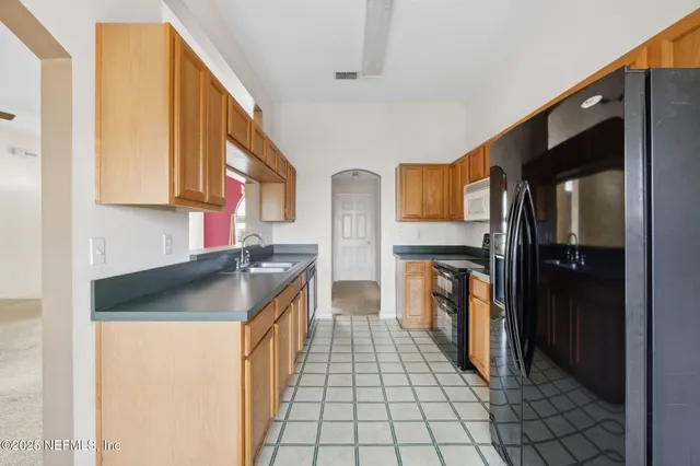 a kitchen with stainless steel appliances granite countertop a refrigerator and a stove top oven