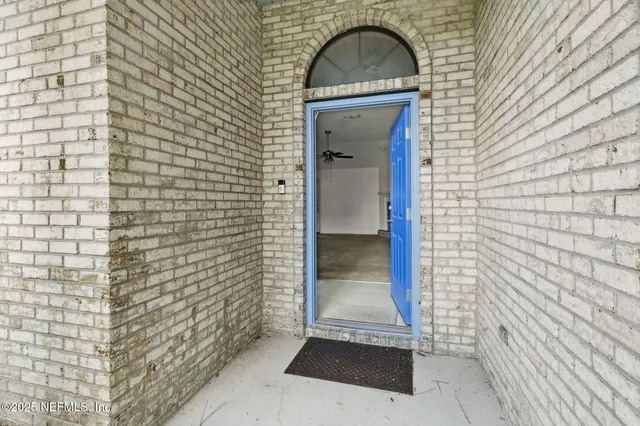 an empty room with mirror and windows