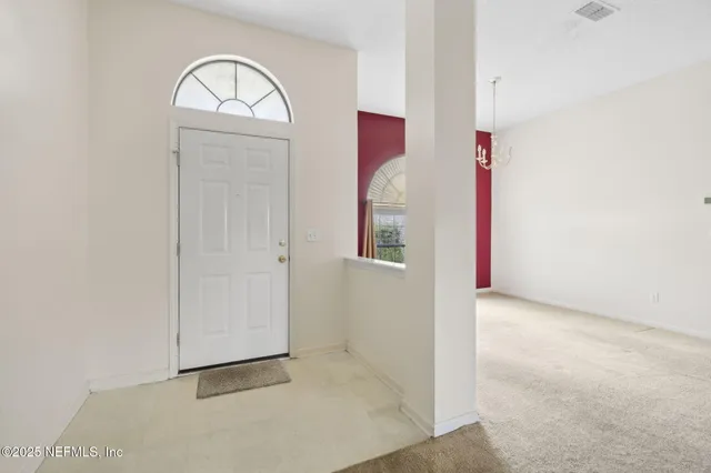 an empty room with windows and fireplace