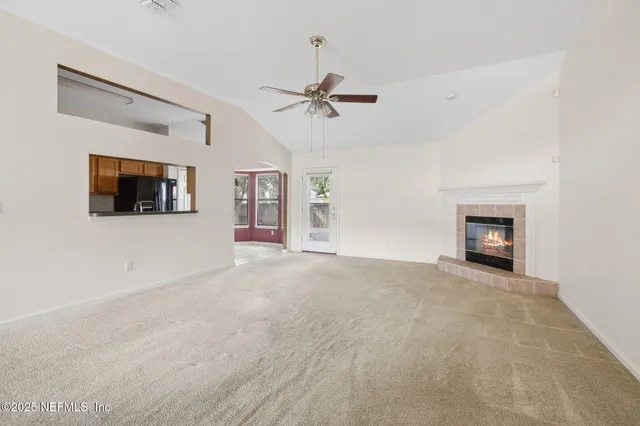 an empty room with windows and fireplace