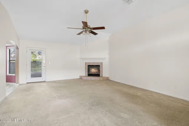 a view of a livingroom with a fireplace and a chandelier fan