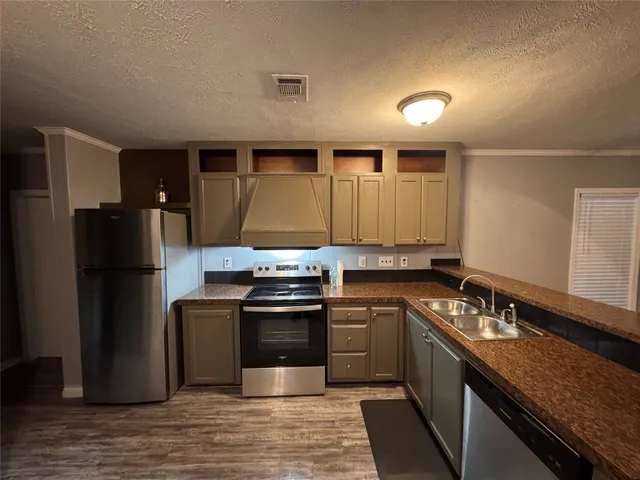 a kitchen with stainless steel appliances granite countertop a sink stove and refrigerator