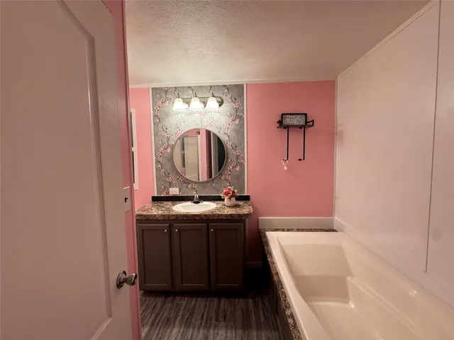 a bathroom with a tub sink and mirror