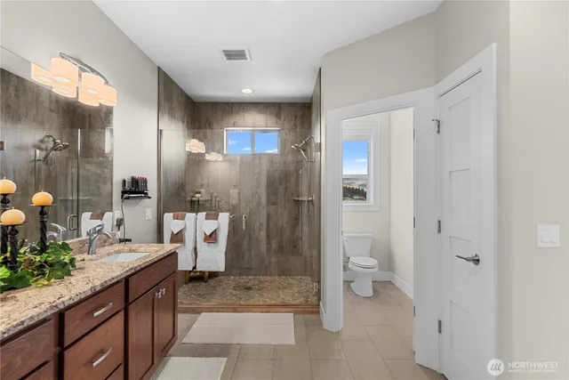 a spacious bathroom with a granite countertop sink toilet and shower