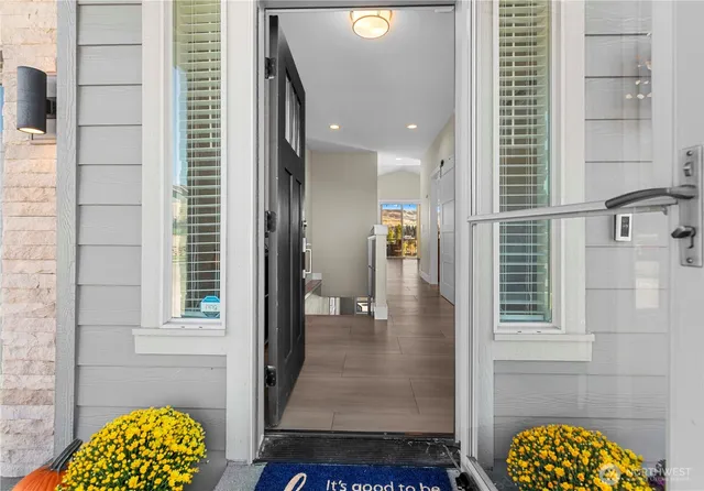 a view of hallway with a door and chandelier