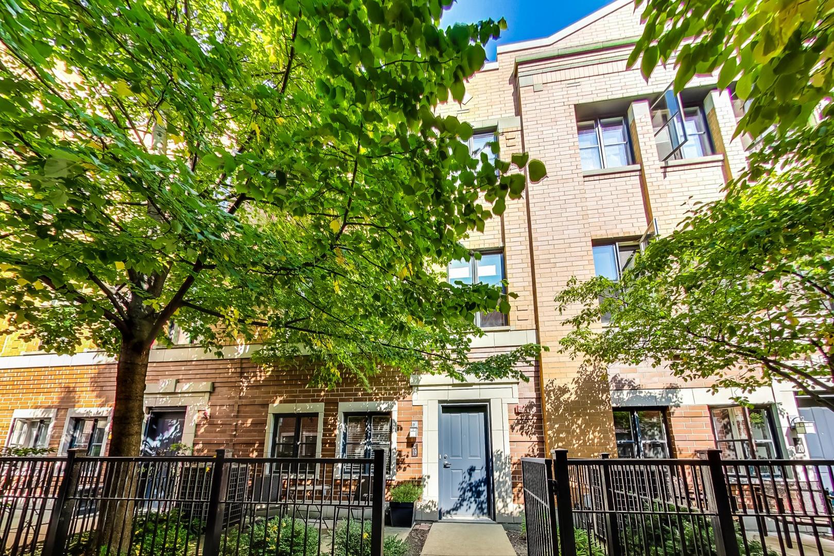 a front view of a house with a tree