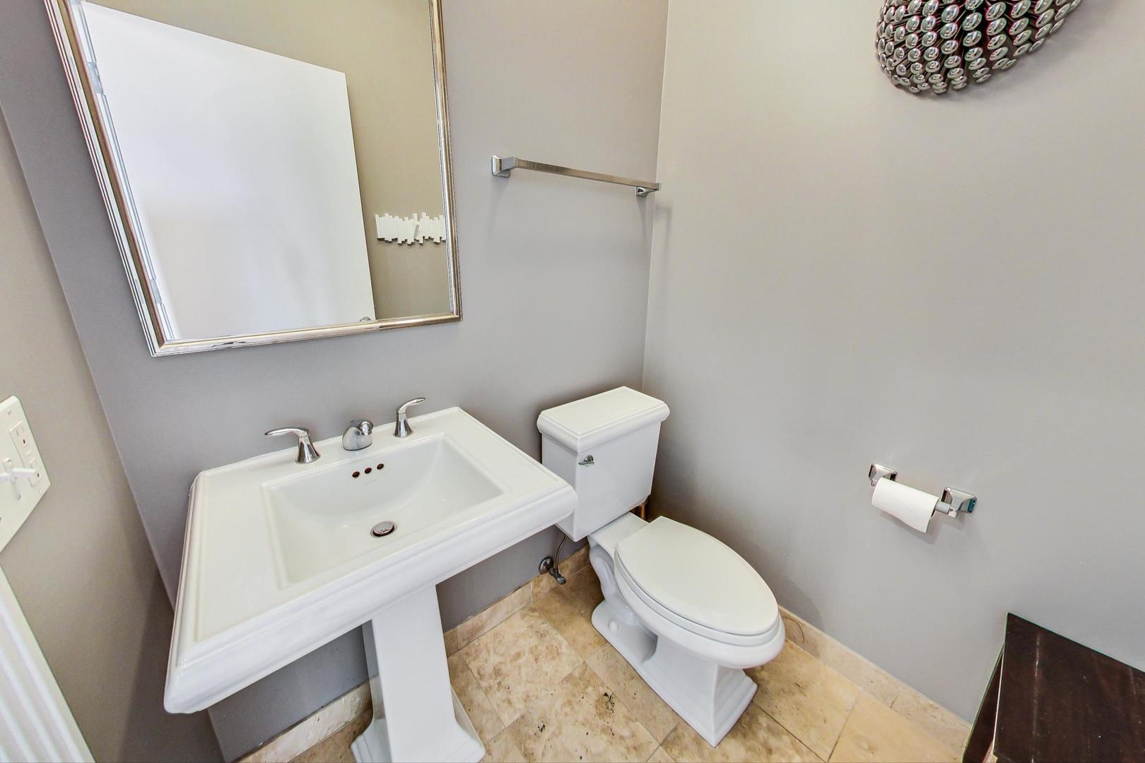 1137 West Monroe Street Chicago, IL 60607 - Photo 13 of 33 a white toilet sitting next to a bathroom sink