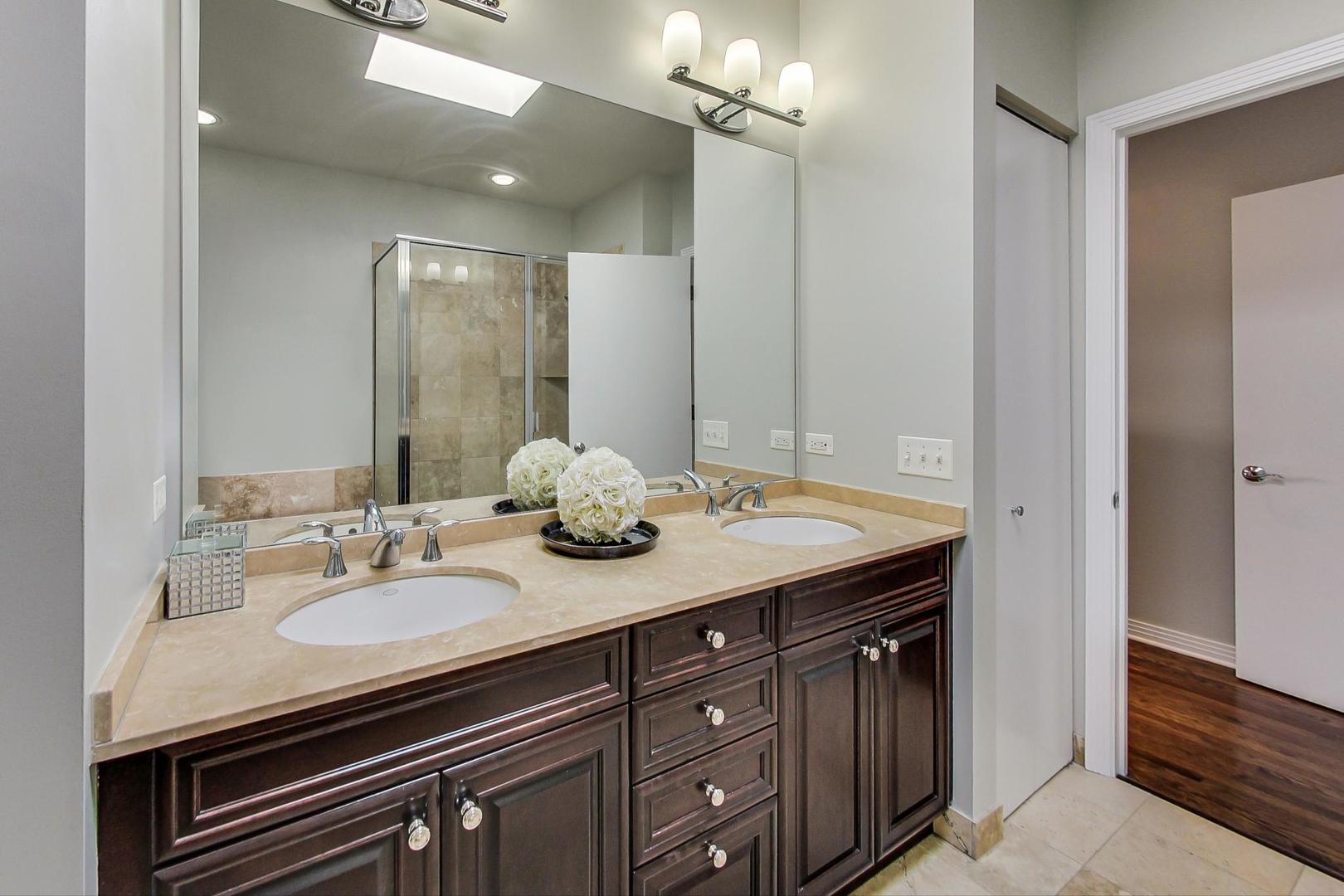 1137 West Monroe Street Chicago, IL 60607 - Photo 16 of 33 a bathroom with a granite countertop sink a mirror and a vanity