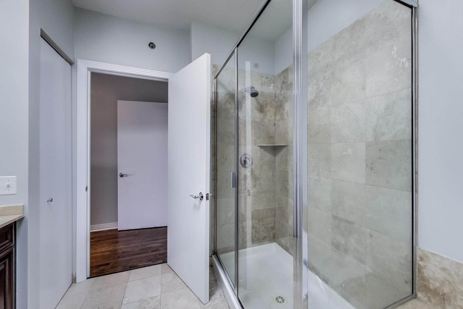 1137 West Monroe Street Chicago, IL 60607 - Photo 18 of 33 a bathroom with a shower and a toilet
