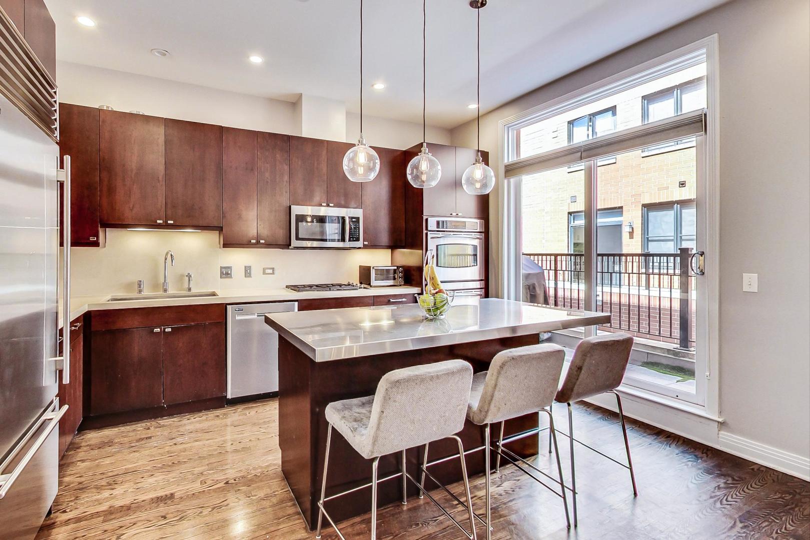 1137 West Monroe Street Chicago, IL 60607 - Photo 8 of 33 a kitchen with a table chairs sink and cabinets