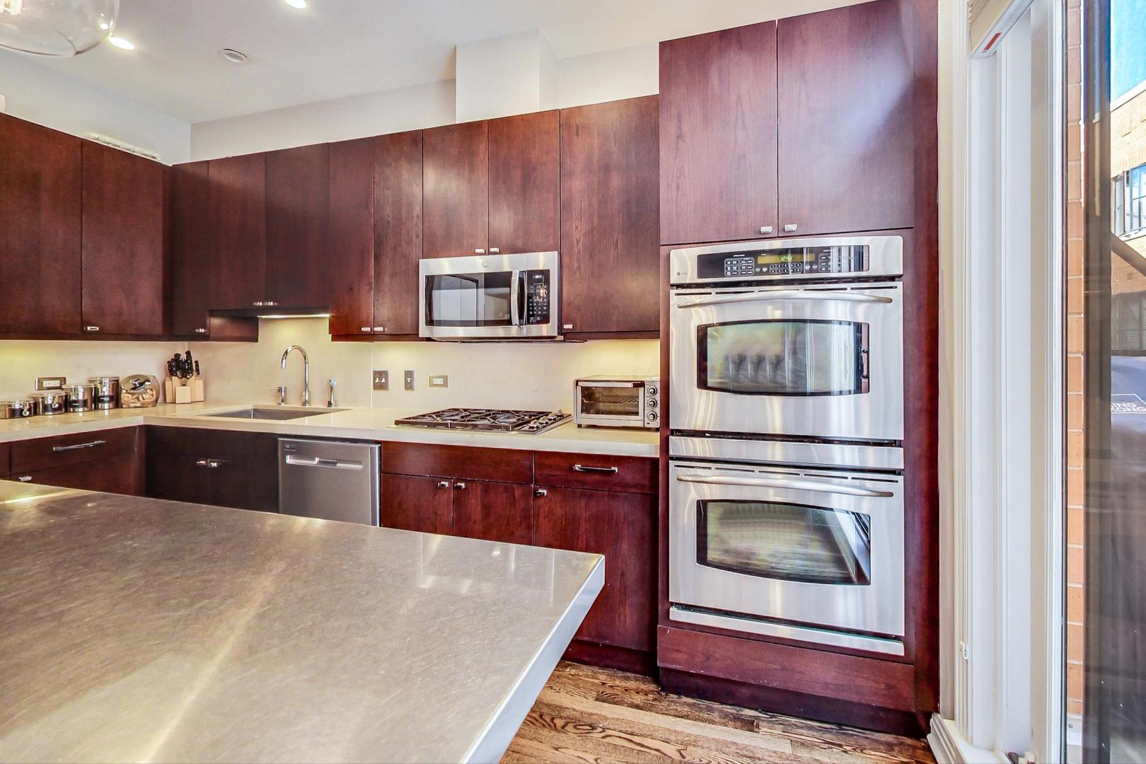 1137 West Monroe Street Chicago, IL 60607 - Photo 9 of 33 a kitchen with a stove a microwave and cabinets