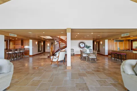 a living room with furniture a dining table and chairs with the large windows
