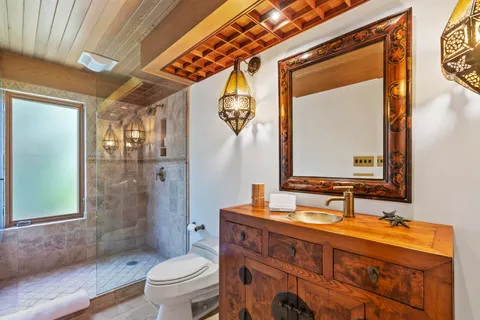 a bathroom with a granite countertop sink toilet a mirror and shower