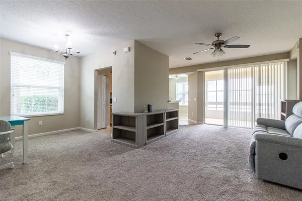 a living room with furniture and a ceiling fan