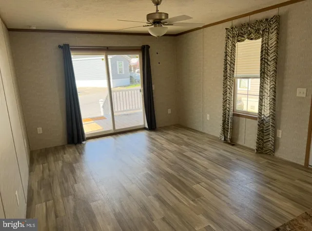 an empty room with wooden floor and windows