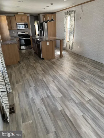 a view of a refrigerator in kitchen and wooden floor