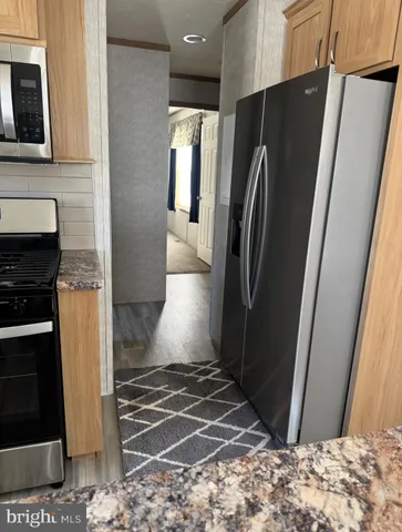 a view of a refrigerator a microwave and cabinets