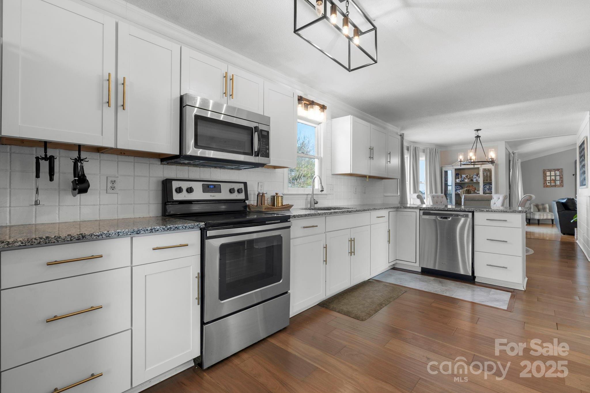 20 Meandering Way Granite Falls, NC 28630 - Photo 23 of 39 a kitchen with stainless steel appliances granite countertop a stove a sink and white cabinets