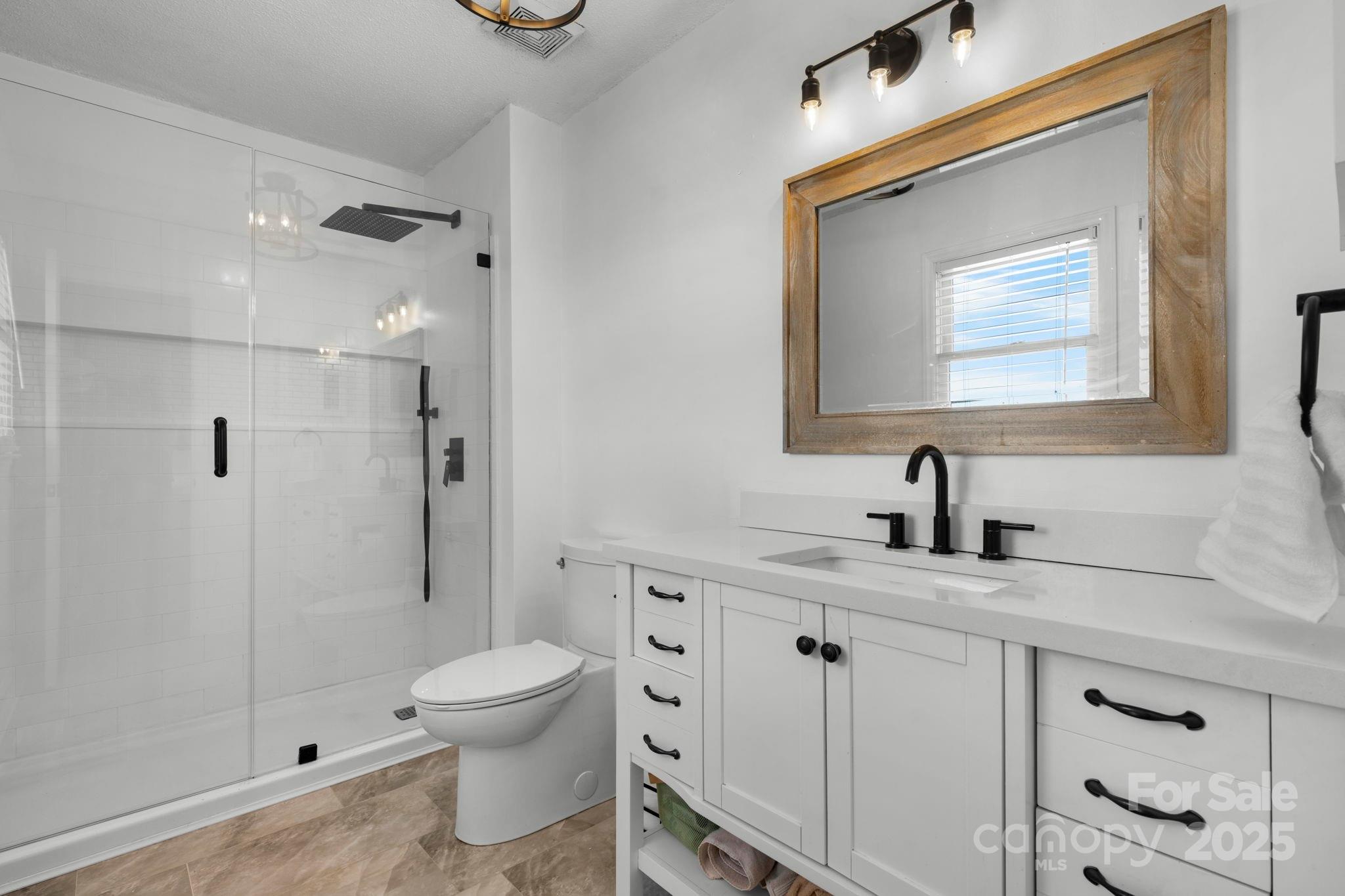 20 Meandering Way Granite Falls, NC 28630 - Photo 30 of 39 a bathroom with a granite countertop sink toilet a mirror a vanity and shower