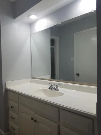 a white toilet sitting next to a white sink and vanity